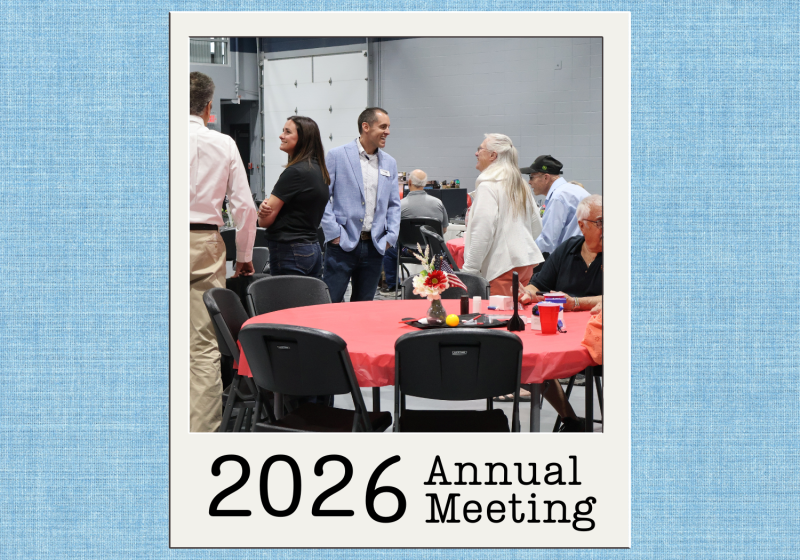 Members and High West Energy representatives visiting during the 2026 Annual Meeting while seated and standing around banquet tables inside the meeting venue.