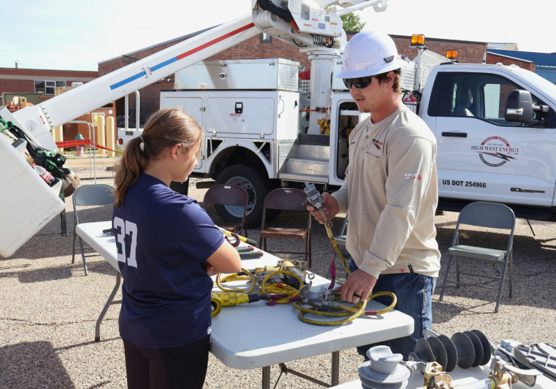 High West Energy representative explaining utility equipment and electrical components during a community education and outreach event.